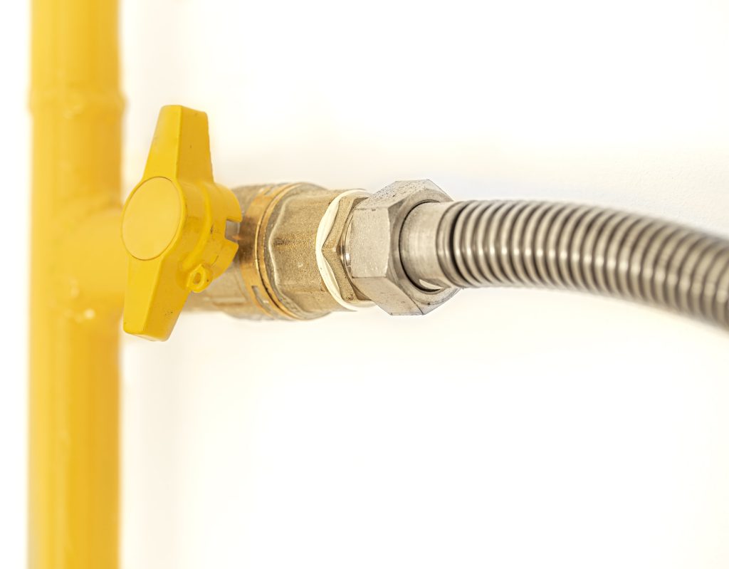 Yellow gas pipe with a valve. White background.